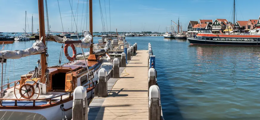 Embarcaciones atracadas en el puerto de Volendam en un día soleado.