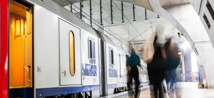 Andén moderno con tren y viajeros en la estación central de Amberes, Bélgica
