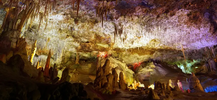Estalactitas y estalagmitas iluminadas en las Cuevas del Hams