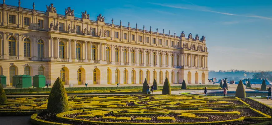 Palacio de Versalles, un gran edificio con numerosas ventanas en su fachada exterior.