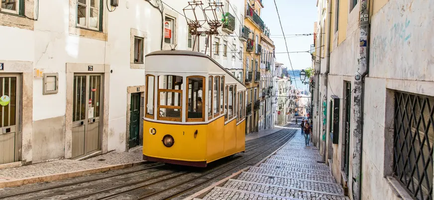 Ascensor da Bica descendiendo por su empinada calle en el centro de Lisboa.