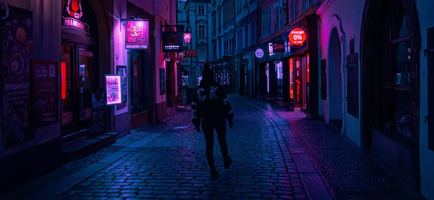 Callejón nocturno iluminado por neones en Praga, República Checa