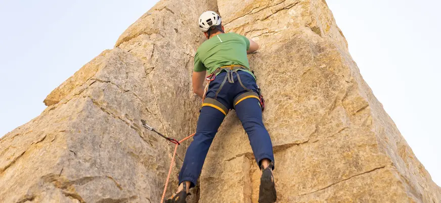 Escalador ascendiendo por una grieta vertical en la roca de El Chorro, Málaga