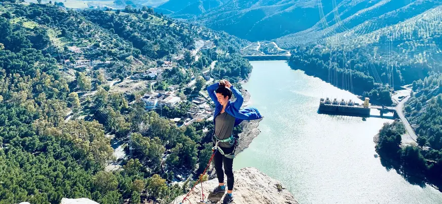 Mujer con arnés en la cima de El Chorro con vistas al embalse