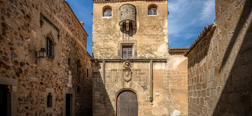 Casa del Sol con su escudo y matacán en Cáceres, España.