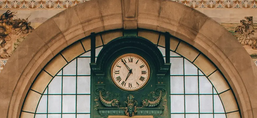 Reloj histórico de la estación de tren São Bento en Oporto, rodeado de azulejos tradicionales portugueses.