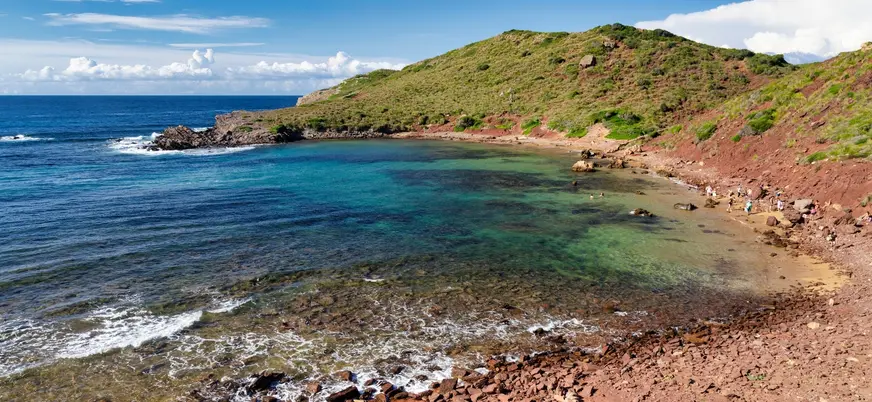 Cala Pregonda con arena roja y aguas claras, norte de Menorca