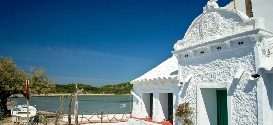Fachada de casa blanca tradicional en el puerto de Es Grau, Menorca