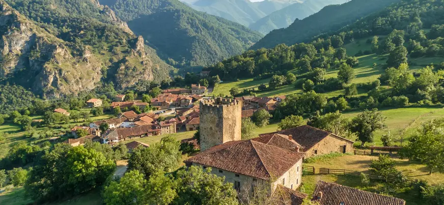 Vista aérea de Mogrovejo con su torre medieval entre montañas en Cantabria