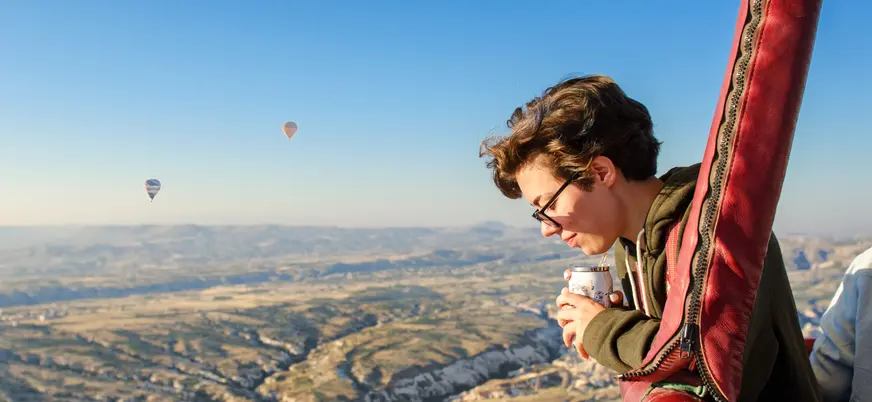 Persona disfrutando vuelo en globo sobre Capadocia al amanecer, Turquía