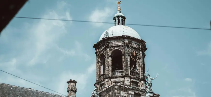 Cúpula del Palacio Real en la Plaza Dam de Ámsterdam bajo un cielo azul