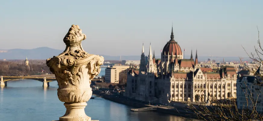 Vista panorámica del Parlamento de Budapest a lo lejos con una urna decorativa.