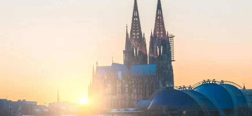 Silueta de la Catedral de Colonia bajo la luz dorada del atardecer.