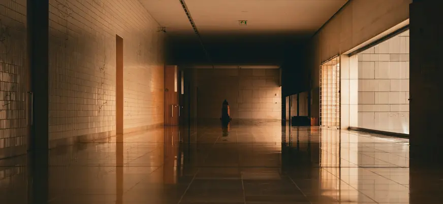 Pasillo interior largo y moderno de la Basílica de la Santísima Trinidad en Fátima, con luz cálida y reflejos.