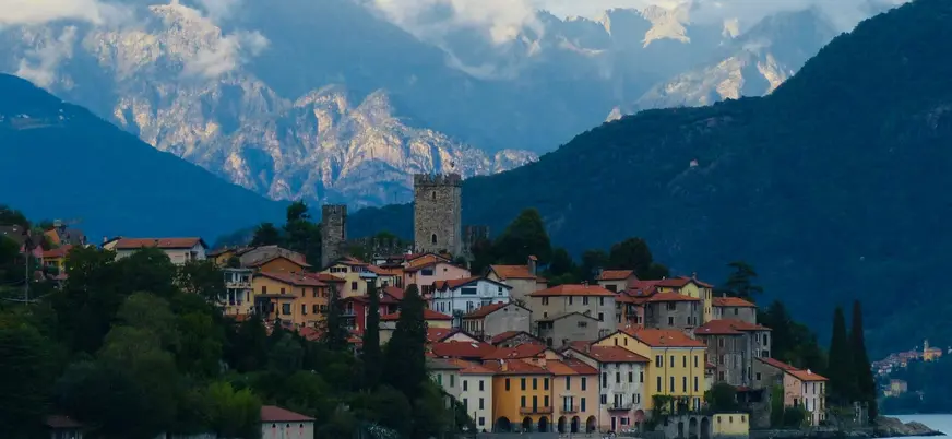 Pueblo histórico a orillas del Lago di Como con montañas nubladas al fondo