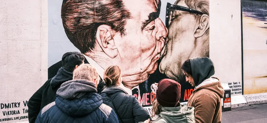 Turistas observando el famoso mural del beso en el Muro de Berlín