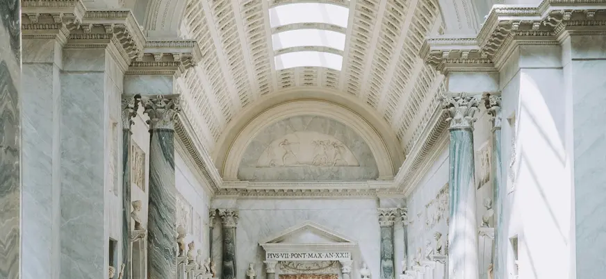 Sala luminosa con columnas y relieves de mármol en los Museos Vaticanos, Ciudad del Vaticano.