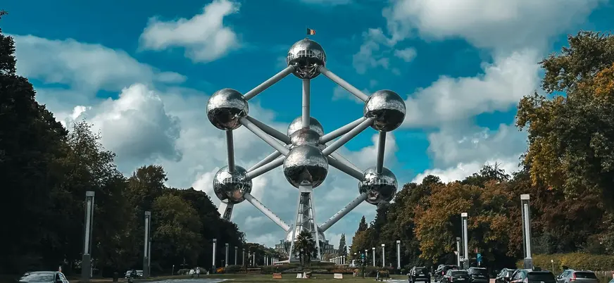 Atomium de Bruselas en Bélgica visto desde la avenida principal entre árboles