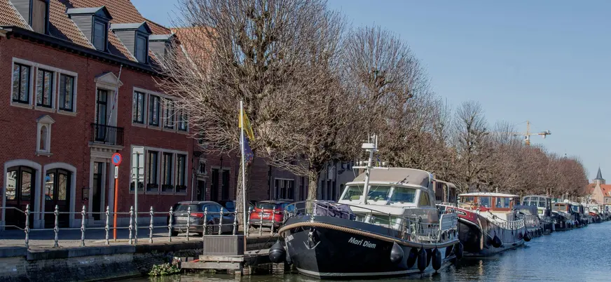 Barcos y casas de ladrillo alineados en un canal de Brujas, Bélgica, en invierno.