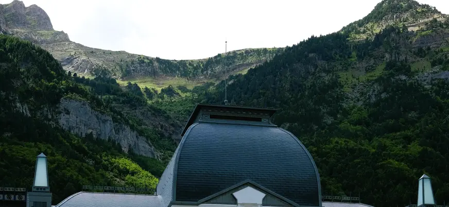  Cúpula y tejado del vestíbulo central de la Estación Internacional de Canfranc con las montañas al fondo.