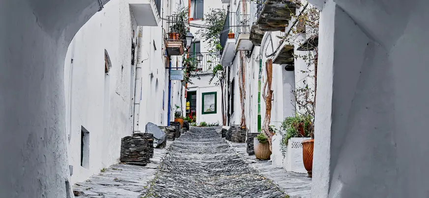 Calle empedrada y casas blancas del casco antiguo de Cadaqués