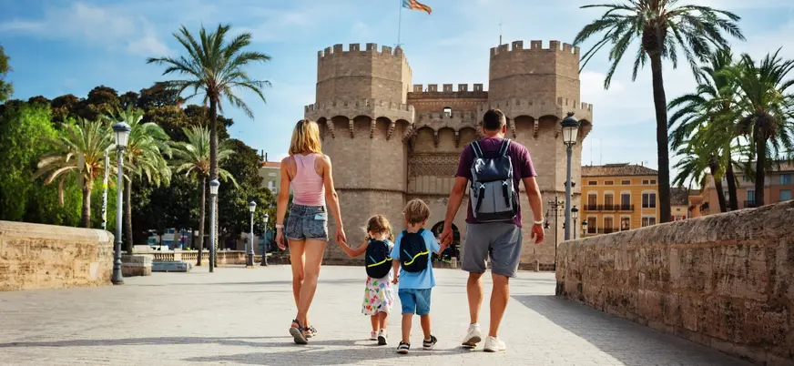 Familia caminando de la mano hacia las Torres de Serranos en Valencia