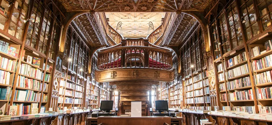 Interior de la Librería Lello en Oporto con escaleras y detalles de madera tallada.