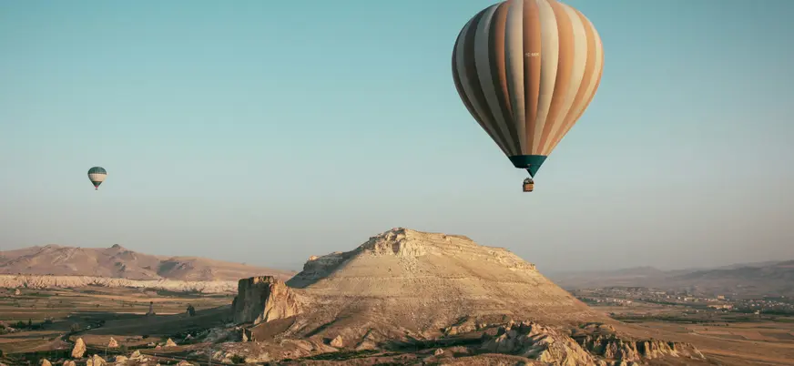 Globo aerostático sobre paisaje de Capadocia al amanecer, Turquía