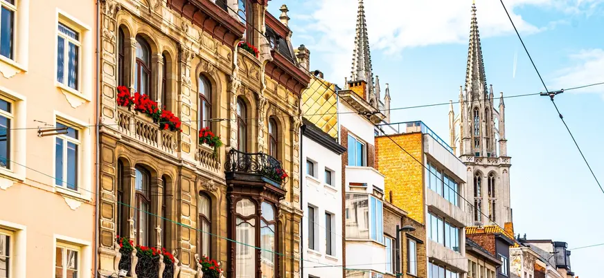 Fachadas históricas y torre gótica en una calle del centro de Amberes, Bélgica