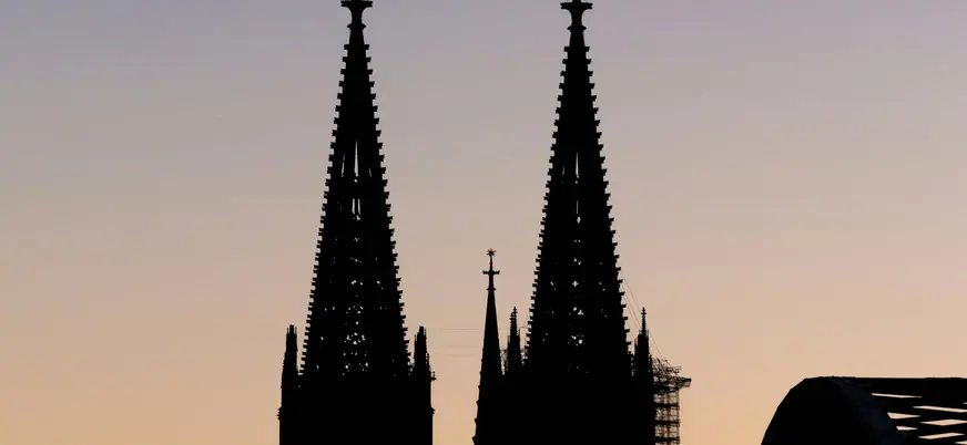 Contraluz de las torres de la Catedral de Colonia frente al cielo del atardecer.