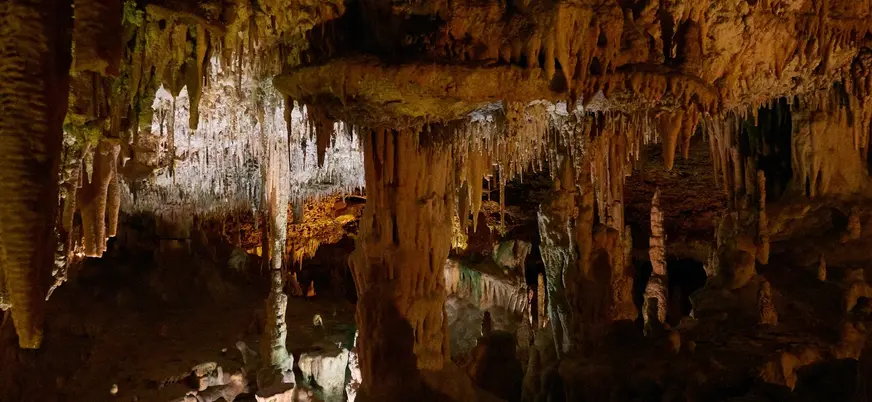 Iluminación colorida sobre estalagmitas y estalactitas en Cuevas dels Hams, Mallorca