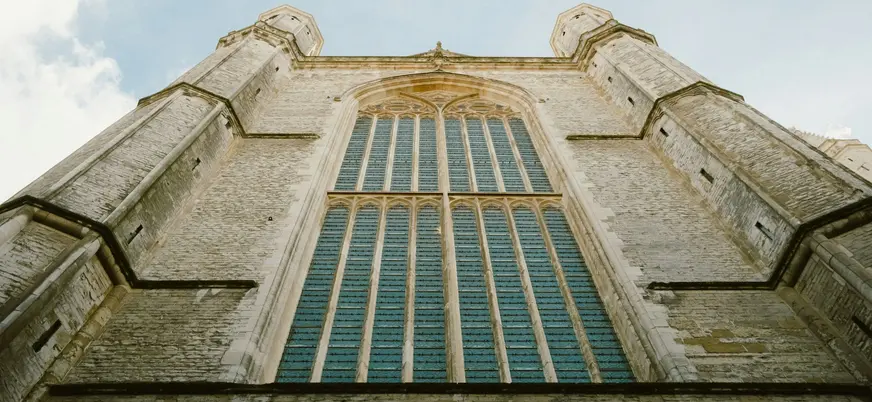 Fachada gótica de piedra con gran ventanal en una iglesia de Gante