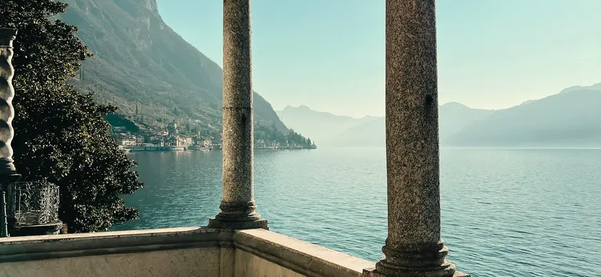 Vista del Lago di Como enmarcada por columnas de piedra desde una terraza