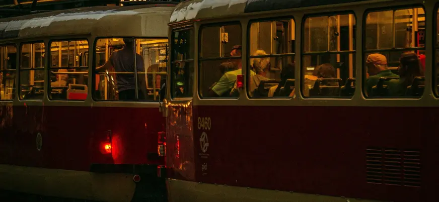 Tranvías iluminados con pasajeros en movimiento en Praga, República Checa