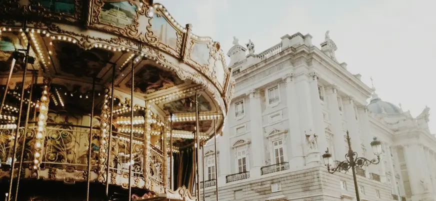 Tiovivo clásico junto a la fachada del Palacio Real de Madrid