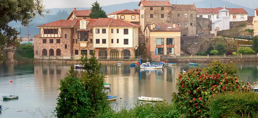 Casas y botes reflejados en la ría de San Vicente de la Barquera, Cantabria