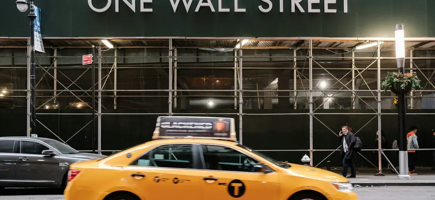 Taxi amarillo frente a One Wall Street en Nueva York, Estados Unidos