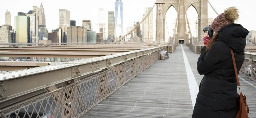 Persona fotografiando el Puente de Brooklyn con skyline de Nueva York, Estados Unidos