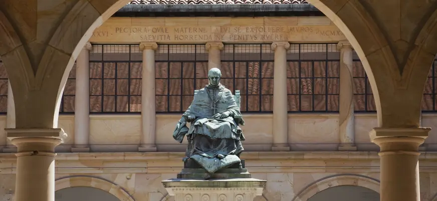 Estatua del arzobispo Valdés Salas en el claustro histórico de la Universidad de Oviedo, símbolo académico de la ciudad.