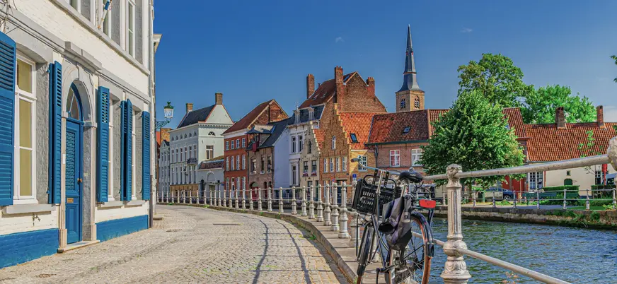 Bicicleta aparcada junto a un canal en el casco antiguo de Brujas, Bélgica.