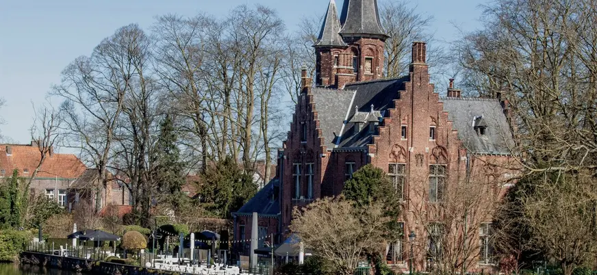Castillo Waalbrug con torres junto al canal Minnewater de Brujas, Bélgica.