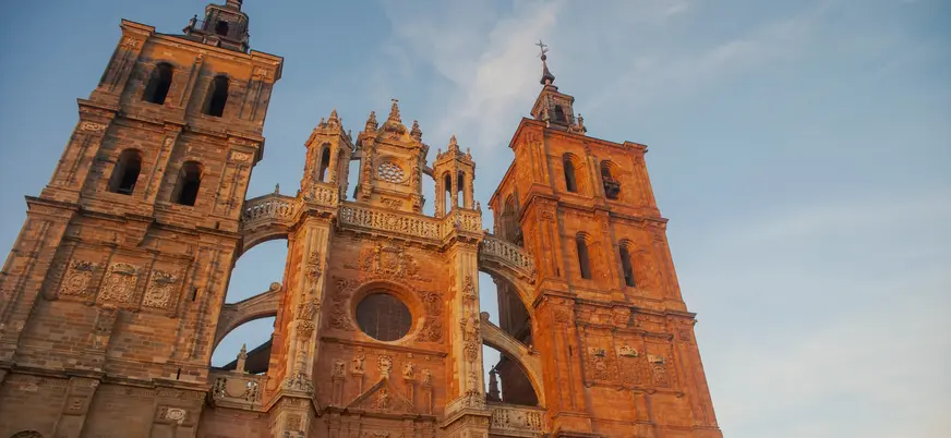 Fachada de la Catedral de Astorga, León, arquitectura gótica y barroca, torres gemelas al atardecer, contrapicada.