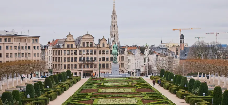 Vista del jardín Mont des Arts en Bruselas, con una estatua ecuestre en el centro y la torre del Ayuntamiento al fondo
