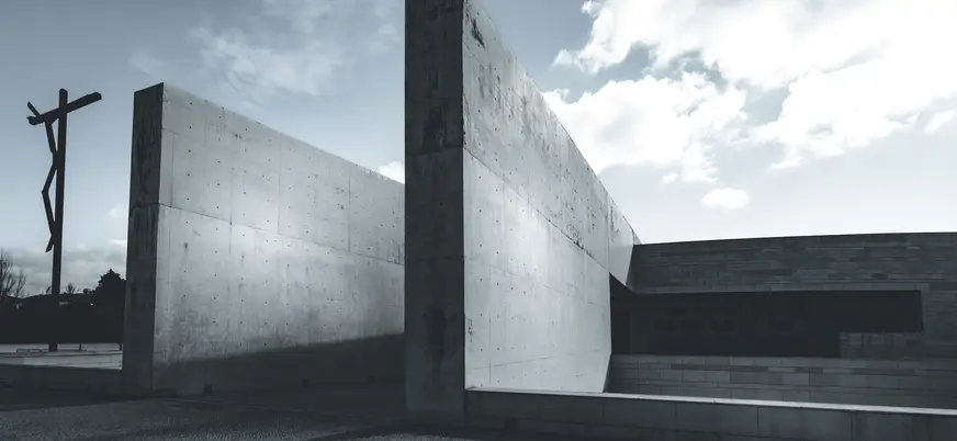 Vista exterior moderna de la Basílica de la Santísima Trinidad en Fátima con muros de hormigón y la Cruz Alta.