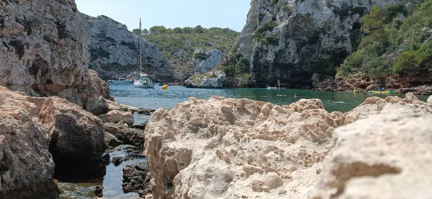 Veleros y kayaks en una cala de Menorca, Baleares