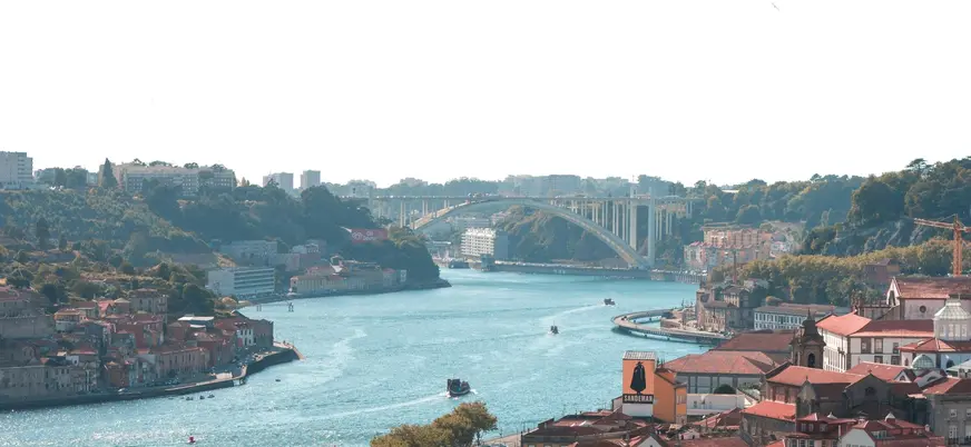 Vista del río Duero en Oporto con el puente de Arrábida al fondo y las casas coloridas de Vila Nova de Gaia.