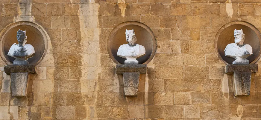 Bustos de los antiguos reyes de Asturias en la fachada de la Catedral de Oviedo, esculturas en piedra sobre muro histórico.