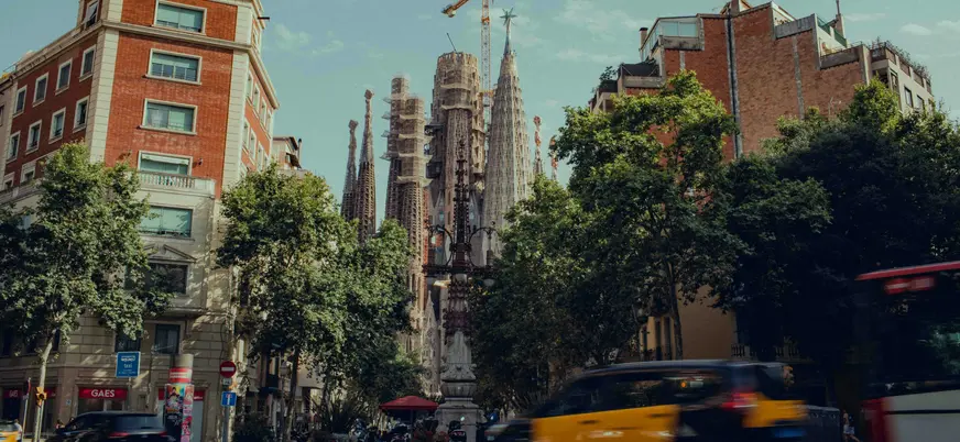 Vista urbana de la Sagrada Familia en Barcelona entre edificios y tráfico