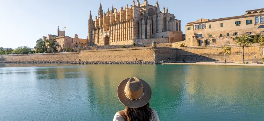 Mujer frente a la Catedral de Palma de Mallorca y el Parc de la Mar