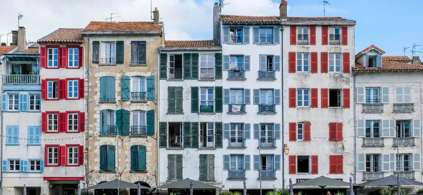 Fachadas con contraventanas de colores en Bayona junto al paseo del río.